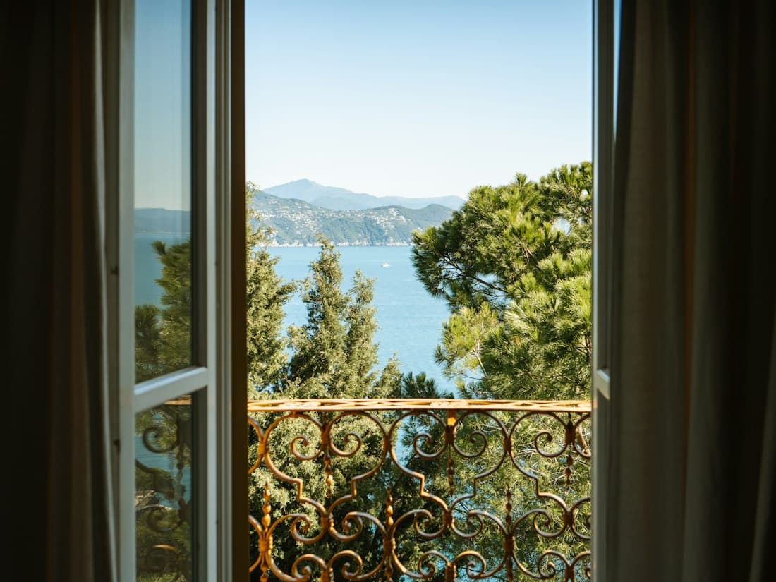 Window opening to a lake and mountains